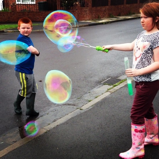 Even blowing giant bubbles is more fun in the rain!